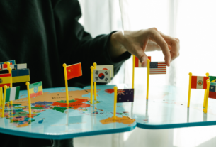 Imagem de uma pessoa com várias bandeiras de Países diferentes em relação a política mundial