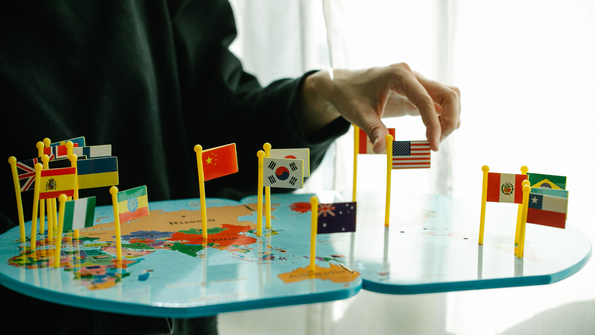 Imagem de uma pessoa com várias bandeiras de Países diferentes em relação a política mundial